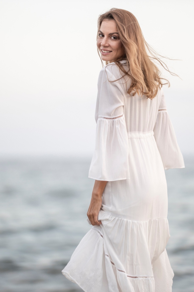 Красивая девушка в белом платье у моря