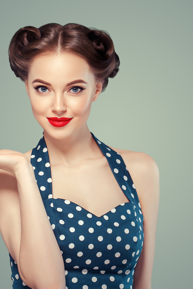 Красивая девушка в платье в горошек на сером фоне