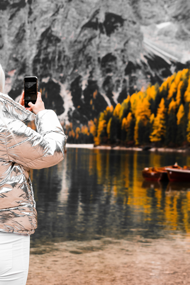 Красивая девушка делает фото гор на телефон 