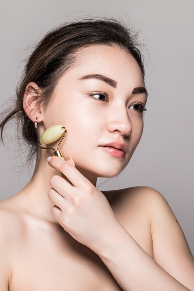 Красивая девушка разглаживает кожу лица