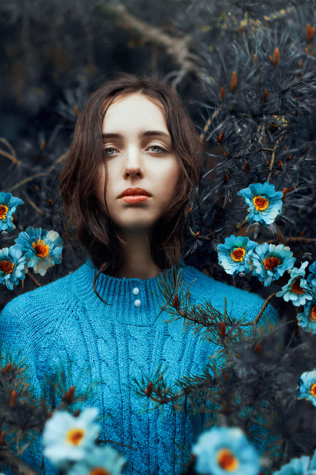 Красивая девушка колючих зарослях с голубыми цветами