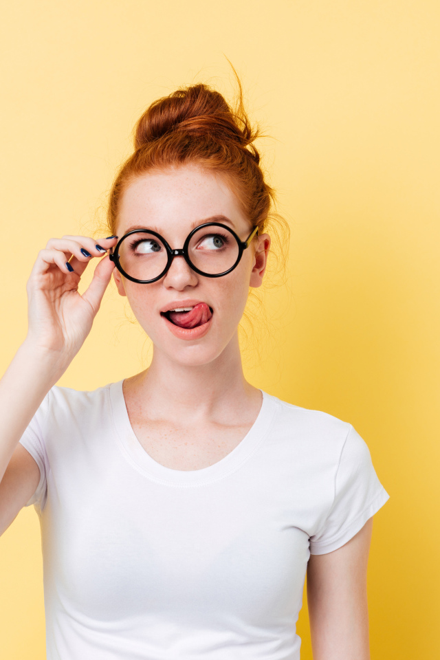 Красивая девушка в очках на желтом фоне 