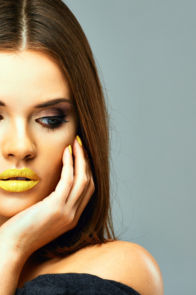 Красивая девушка с желтыми губами на сером фоне