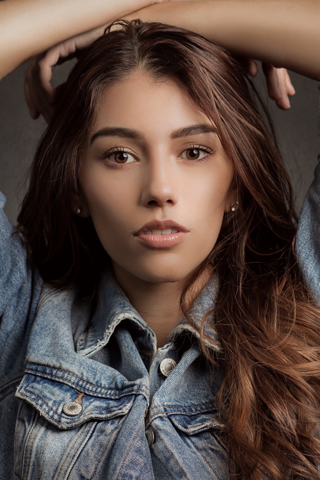 Красивая длинноволосая шатенка в джинсовой куртке 