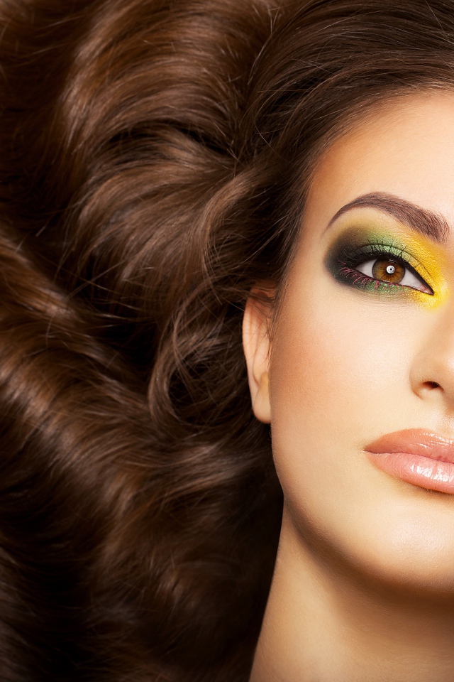 Красивая длинноволосая девушка с ярким макияжем на глазах 