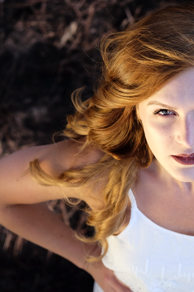 Красивый взгляд рыжеволосой девушки в белом платье