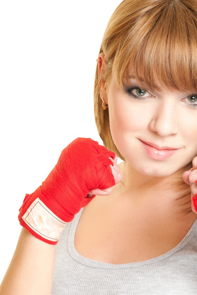 Красивая рыжеволосая девушка в стойке боксера на белом фоне