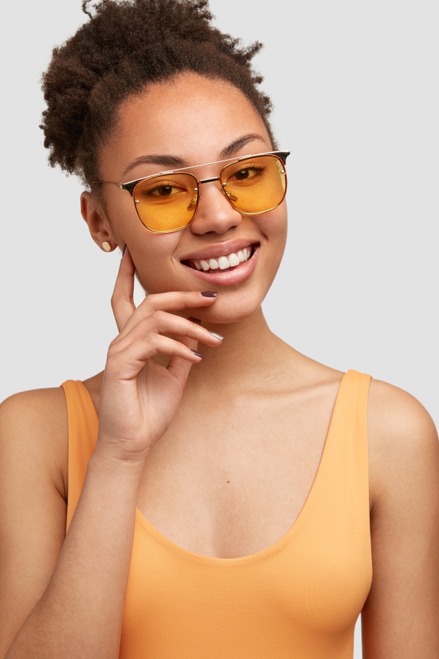 Красивая улыбающаяся темнокожая девушка в солнечных очках