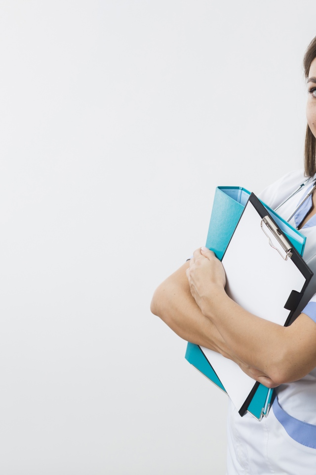 Красивая улыбающаяся девушка врач с папками на белом фоне 