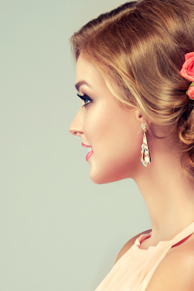 Красивая свадебная прическа у молодой девушки на сером фоне 