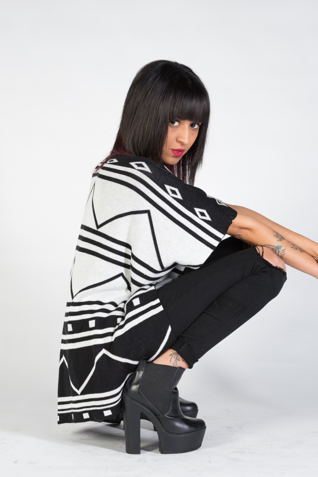 Брюнетка сидит на корточках 