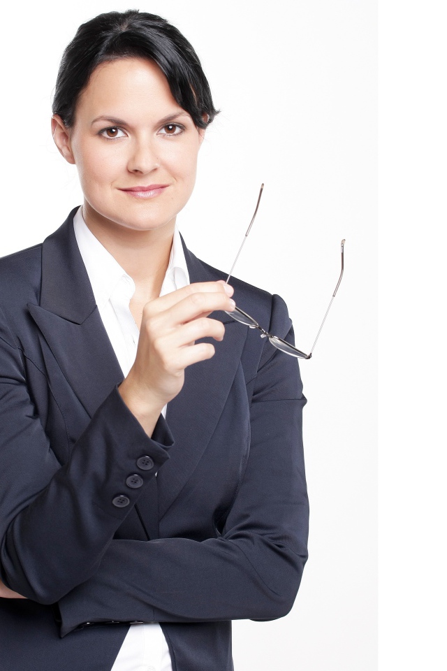 Деловая женщина в костюме с очками в руке