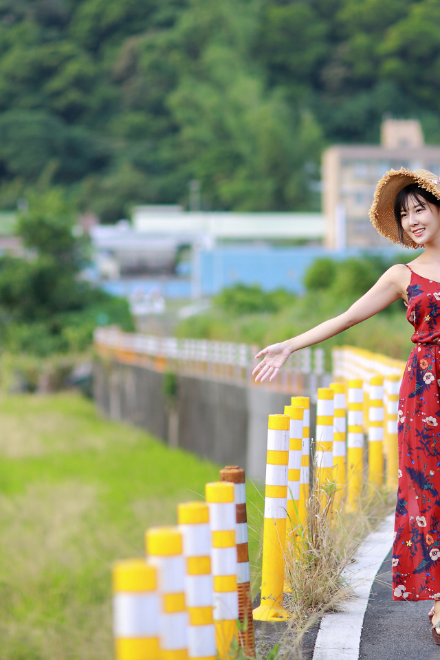 Веселая девушка азиатка в цветастом сарафане 