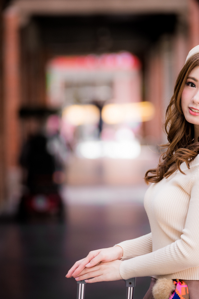 Милая азиатка в берете на вокзале