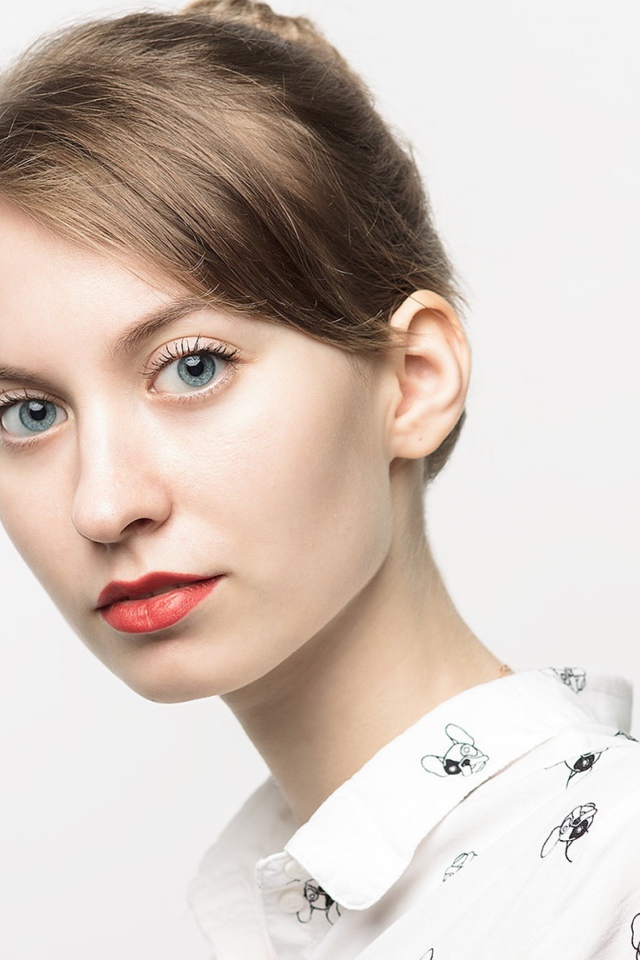 Милая голубоглазая девушка в рубашке на сером фоне