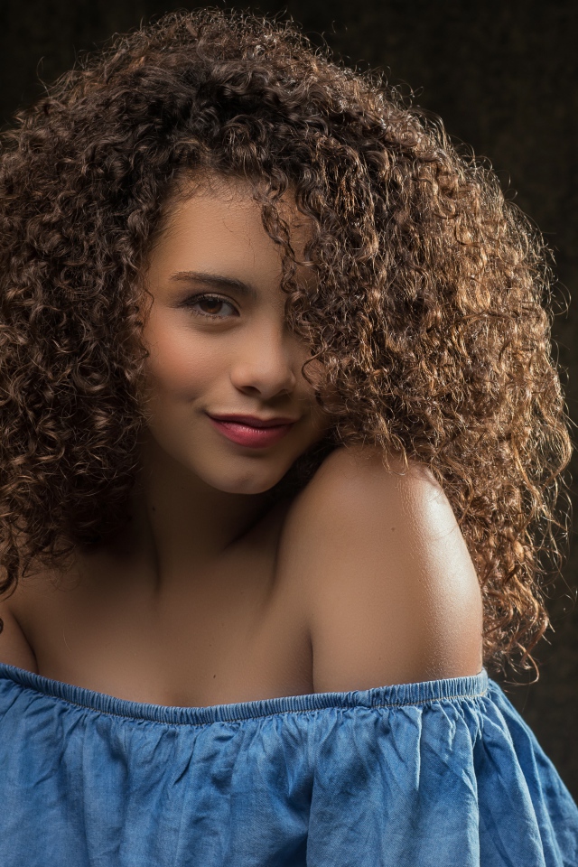 Милая кудрявая девушка в платье