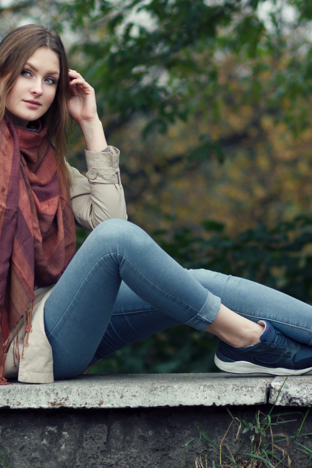 Милая девушка в куртке и синих джинсах 