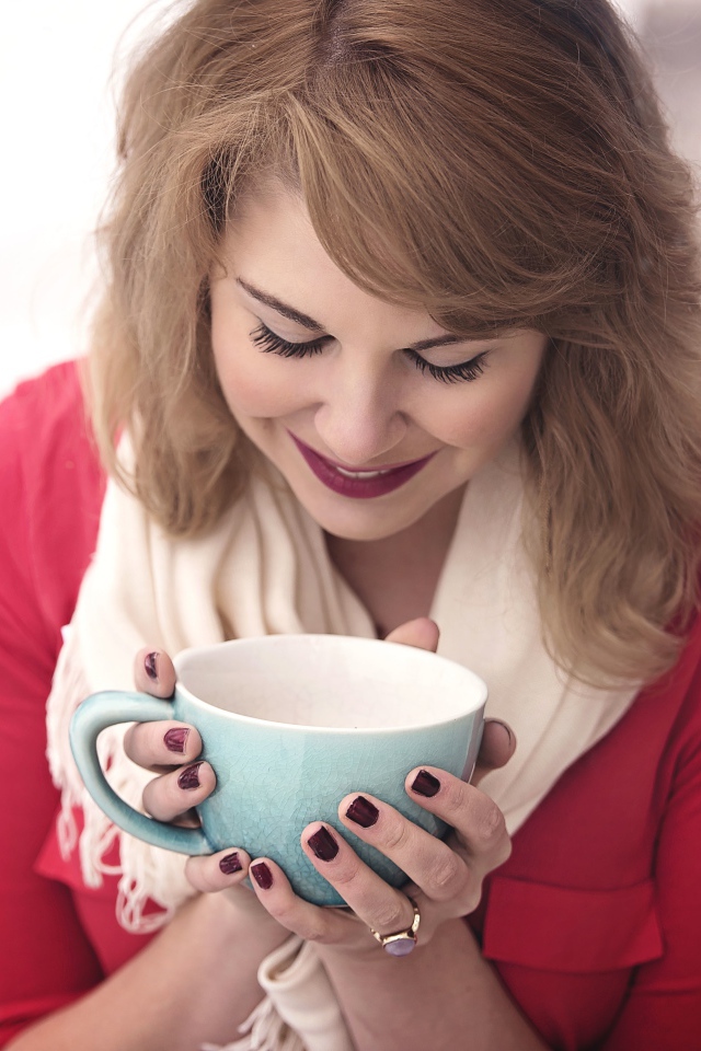 Милая девушка согревается горячим кофе