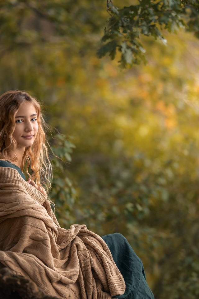 Милая длинноволосая девушка в теплой накидке 