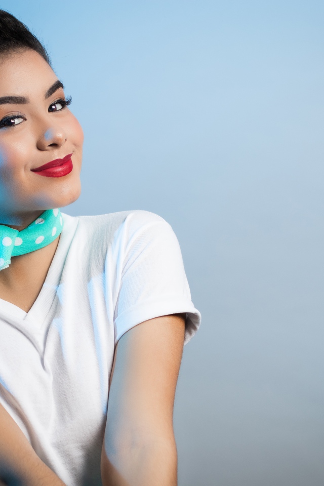 Милая улыбающаяся девушка с шарфом на шее на сером фоне