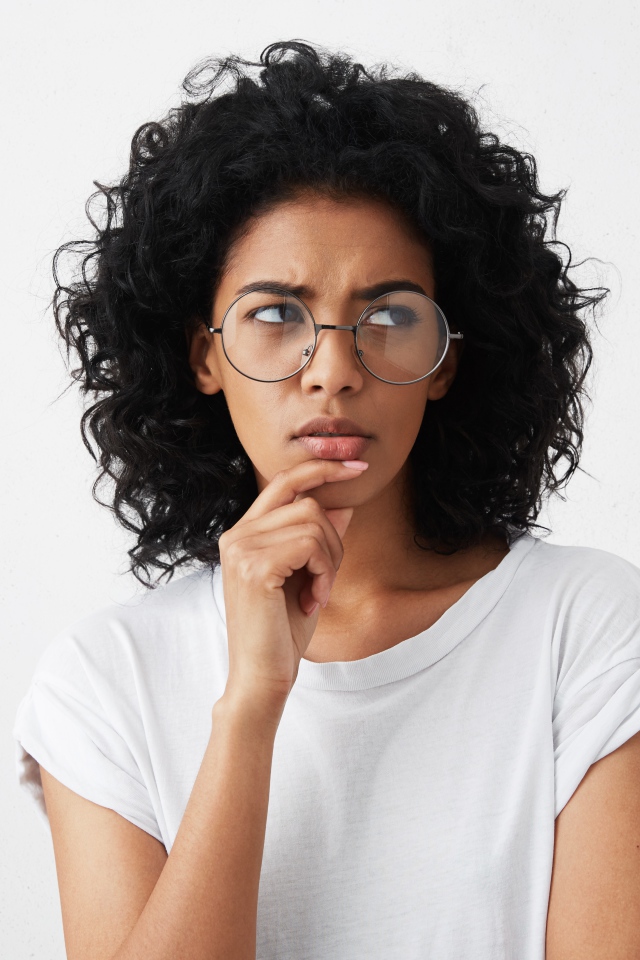 Темноволосая девушка в очках на сером фоне