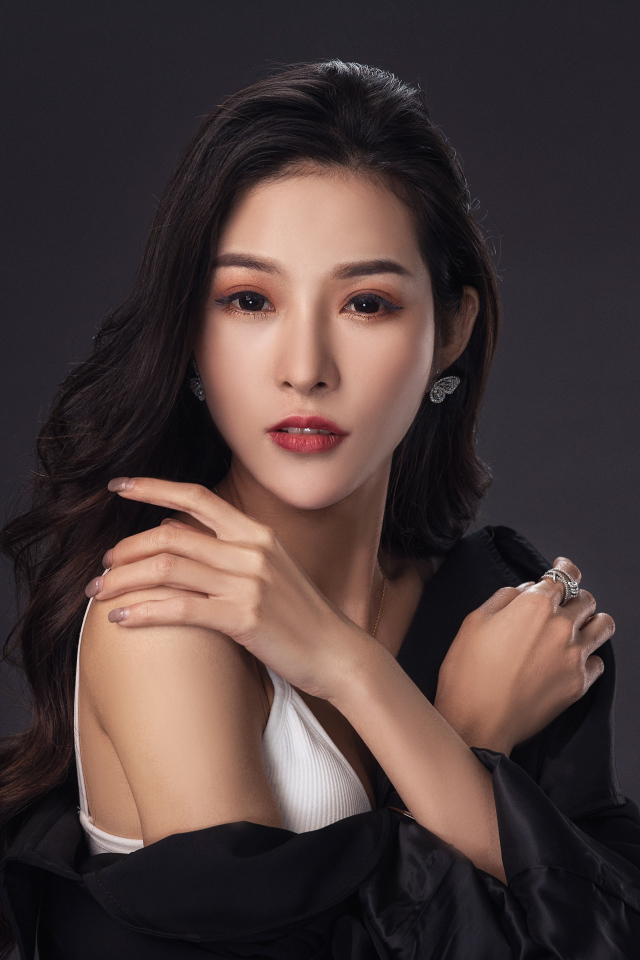 Нежная длинноволосая азиатка на сером фоне