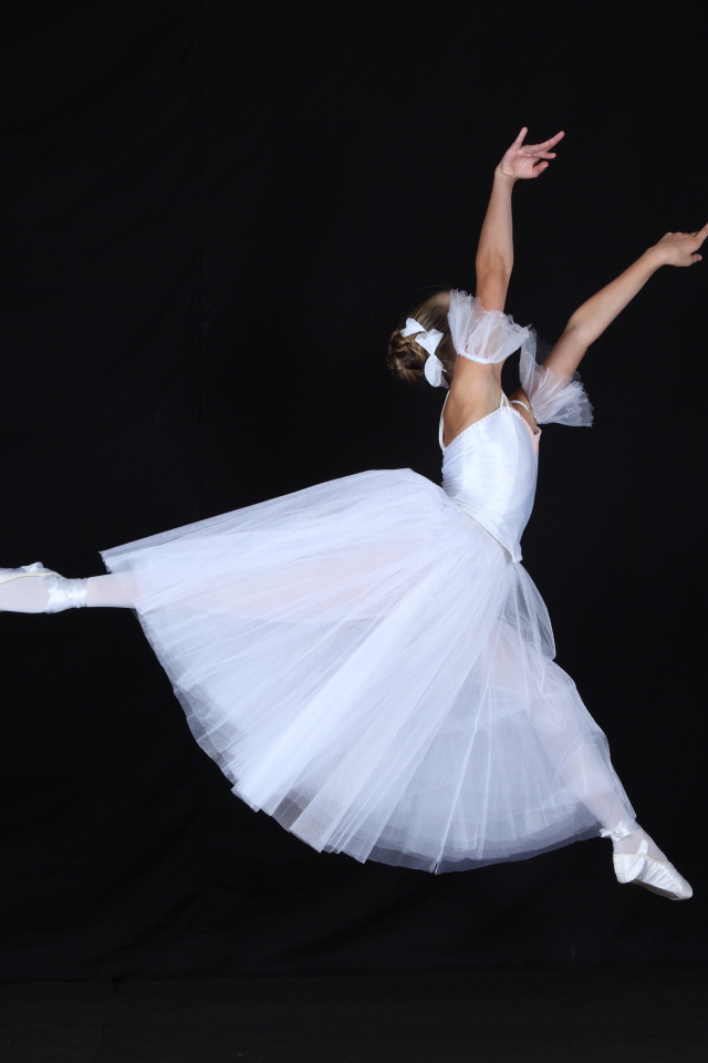 Девушка балерина в белом платье на черном фоне