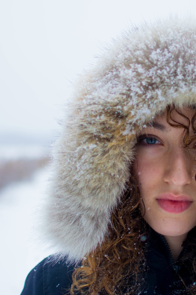 Девушка в заснеженном капюшоне на улице