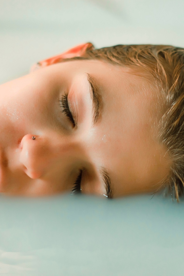Девушка лежит с закрытыми глазами в ванной