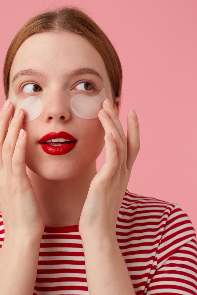 Девушка приклеивает патчи для глаз на лицо 