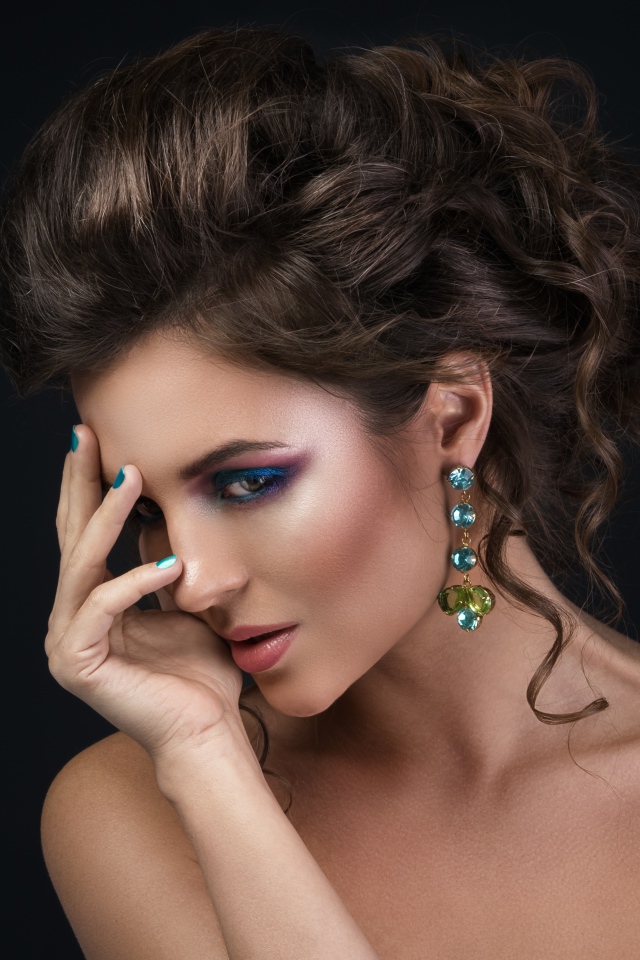 Девушка с красивой вечерней прической на сером фоне