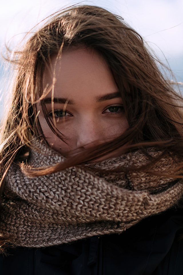 Девушка с теплым вязаным шарфом на лице
