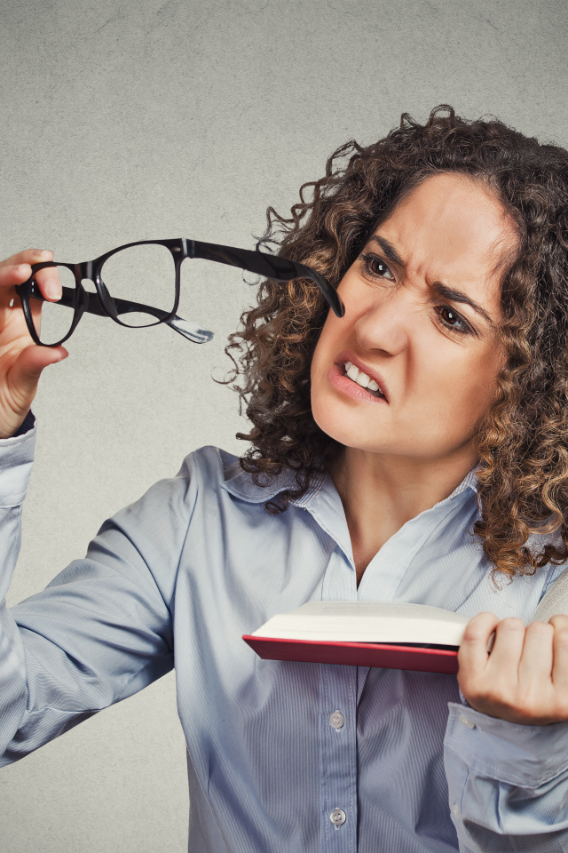 Девушка с книгой с очками в руке