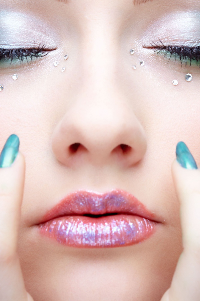 Девушка  с ярким макияжем и стразами на лице 