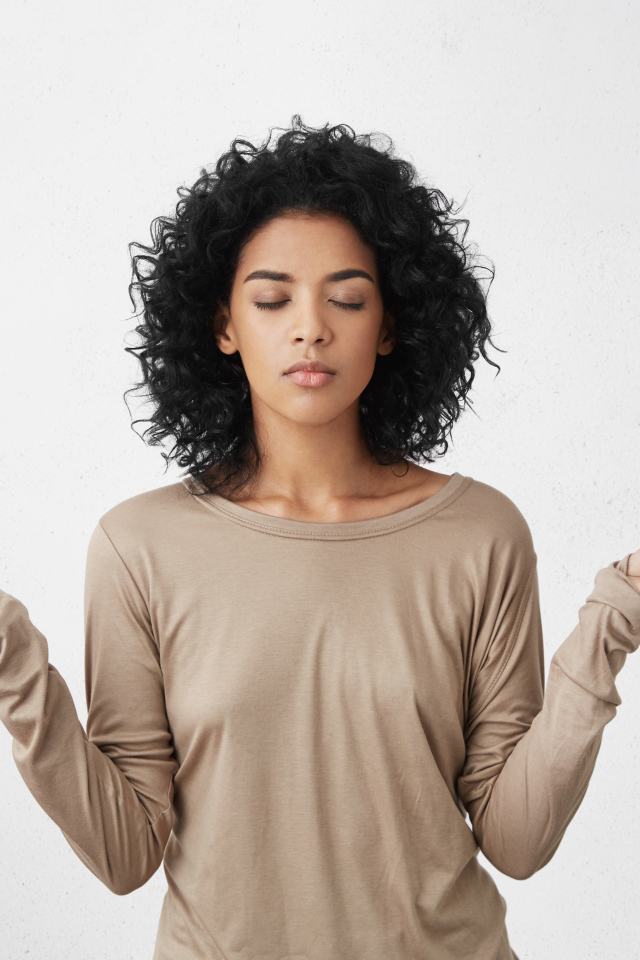 Девушка с закрытыми глазами медитирует 