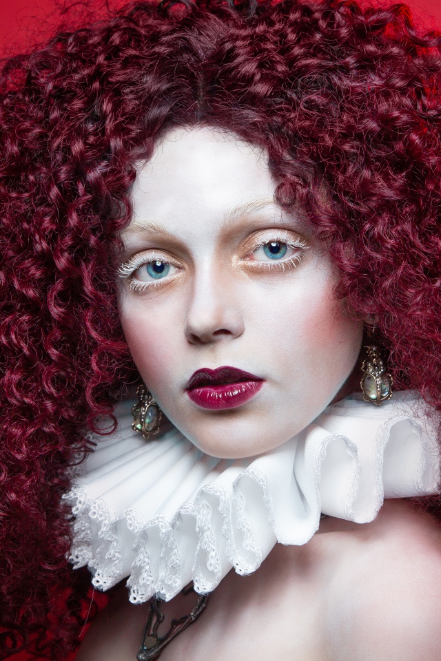 Девушка с красными кудрявыми волосами с белым воротником