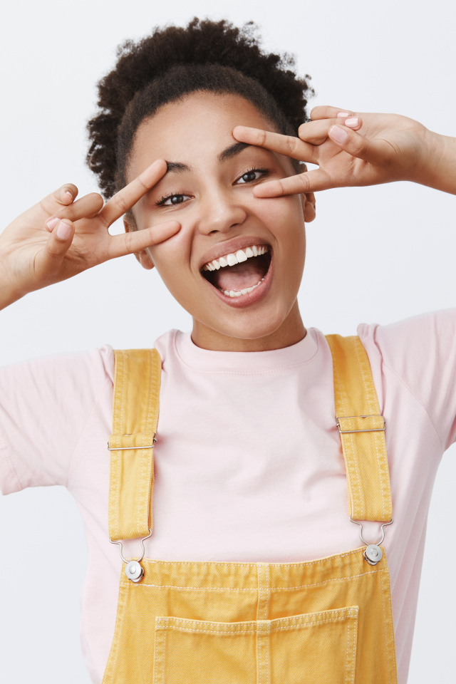 Счастливая девушка с руками у лица 