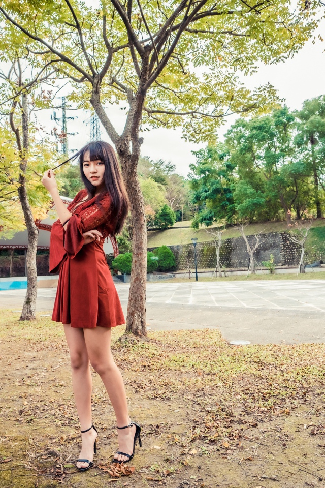 Длинноногая девушка азиатка в коротком красном платье 