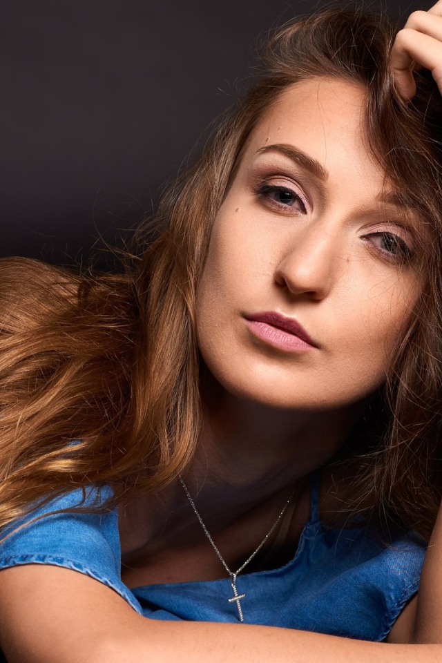 Длинноволосая шатенка лежит на полу в голубом платье 