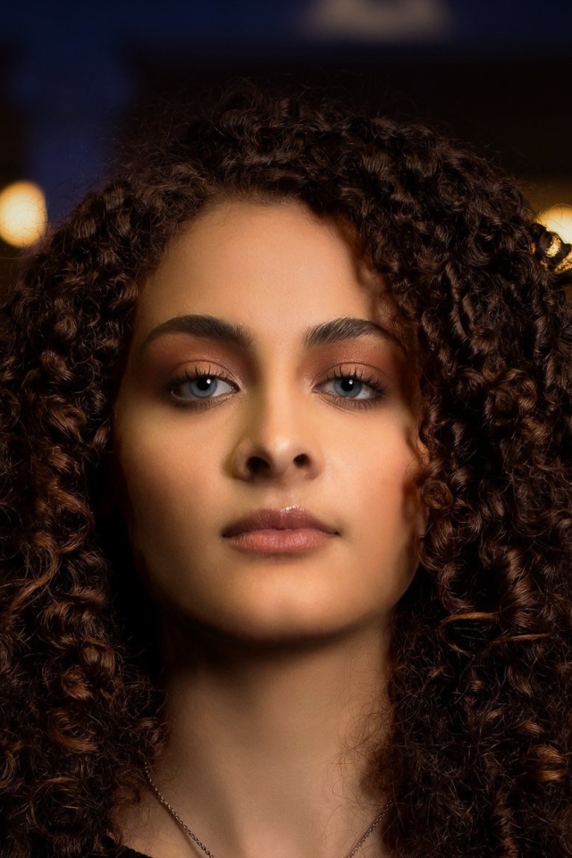 Длинные кудрявые волосы у красивой голубоглазой девушки