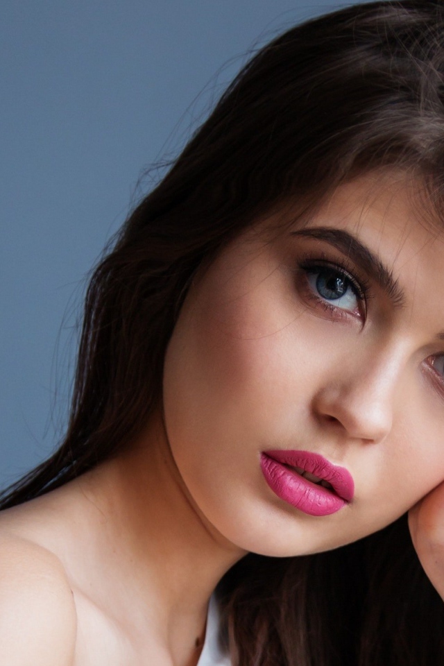 Милая девушка с розовыми губами на сером фоне