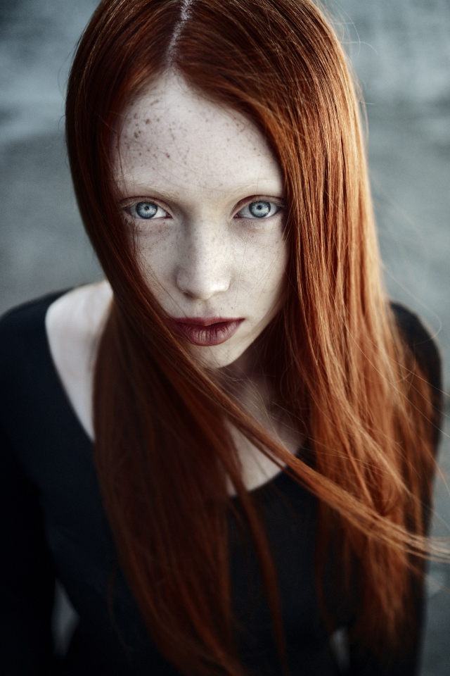 Рыжая длинноволосая девушка с веснушками на лице