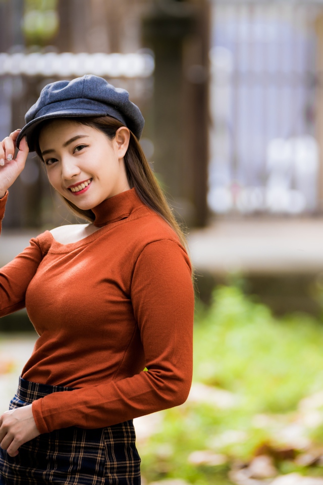 Улыбающаяся девушка азиатка в кепке 