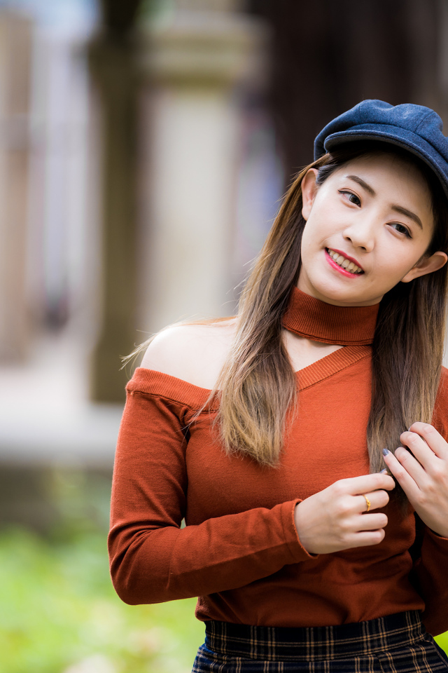 Улыбающаяся азиатка в черной кепке 