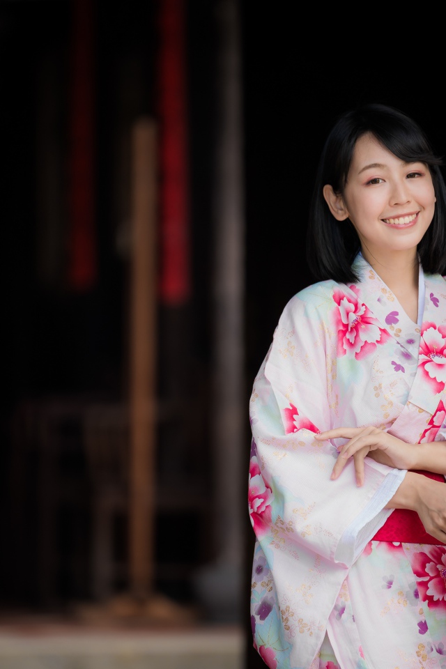 Улыбающаяся девушка азиатка в кимоно с веером в руке
