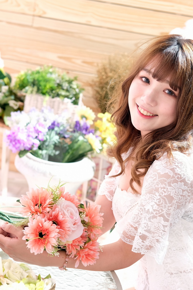 Улыбающаяся девушка азиатка в белом кружевном платье 