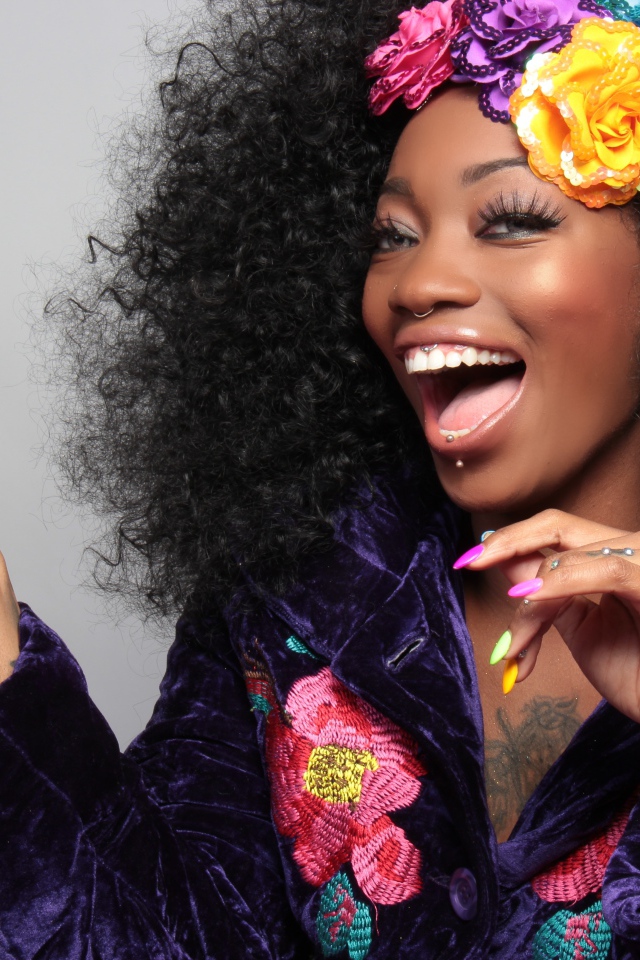 Улыбающаяся темнокожая девушка с цветами в волосах 