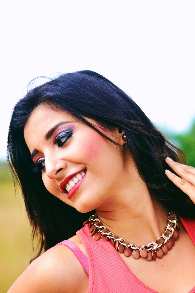 Улыбающаяся темноволосая девушка с украшением на шее 