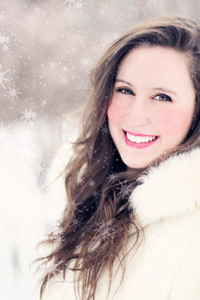 Улыбающаяся девушка в белой шубе на улице зимой 