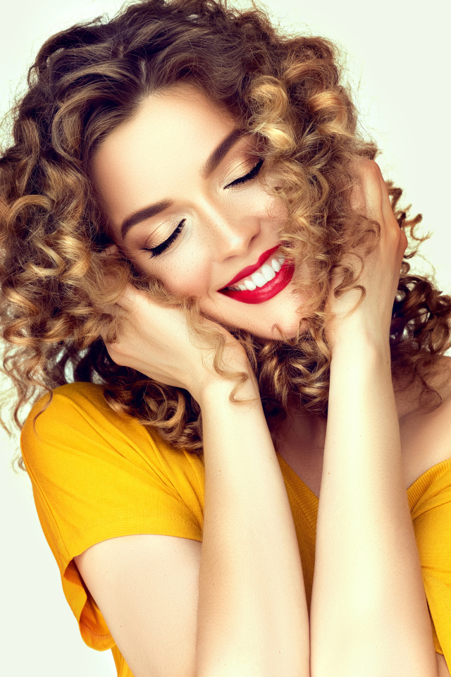 Улыбающаяся девушка с закрытыми глазами на белом фоне